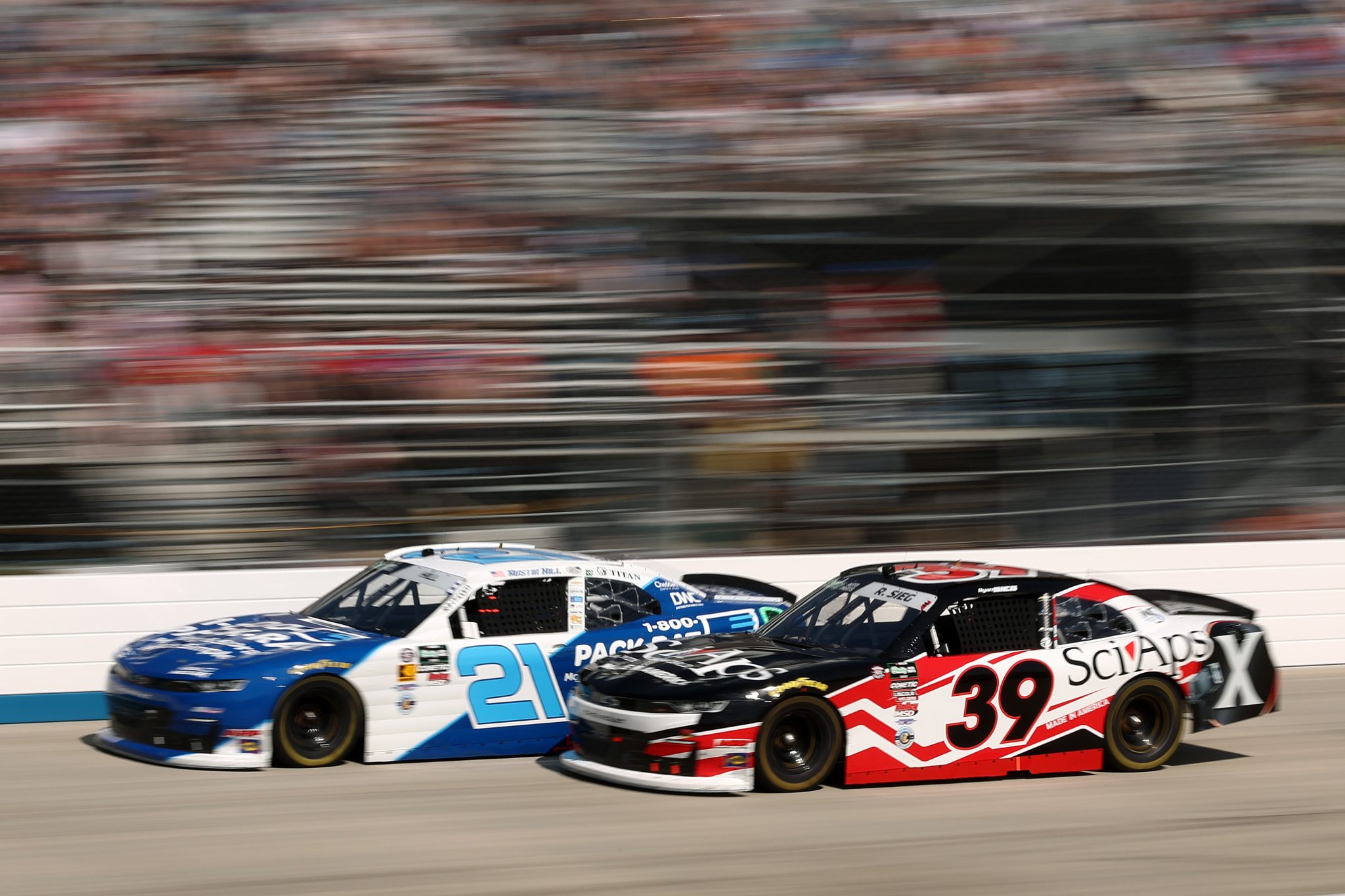 DOVER, DELAWARE - MAY 16: Ryan Sieg, driver of the #39 SciAps Chevrolet, and Austin Hill, driver of the #21 1-800-PACK-RAT Chevrolet, race during the NASCAR O'Reilly Auto Parts Series BetRivers 200 at Dover Motor Speedway on May 16, 2026 in Dover, Delaware. (Photo by Meg Oliphant/Getty Images) | Getty Images