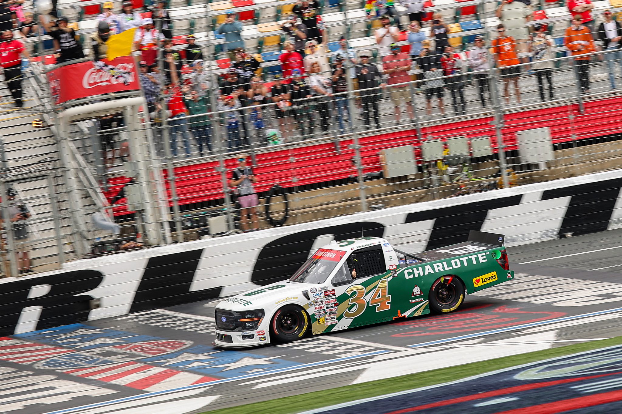 CONCORD, NORTH CAROLINA - MAY 24: Layne Riggs, driver of the #34 University of North Carolina at Charlotte Ford, takes the checkered flag under caution to win the NASCAR Craftsman Truck Series North Carolina Education Lottery 200 at Charlotte Motor Speedway on May 24, 2026 in Concord, North Carolina. (Photo by Jonathan Bachman/Getty Images) | Getty Images