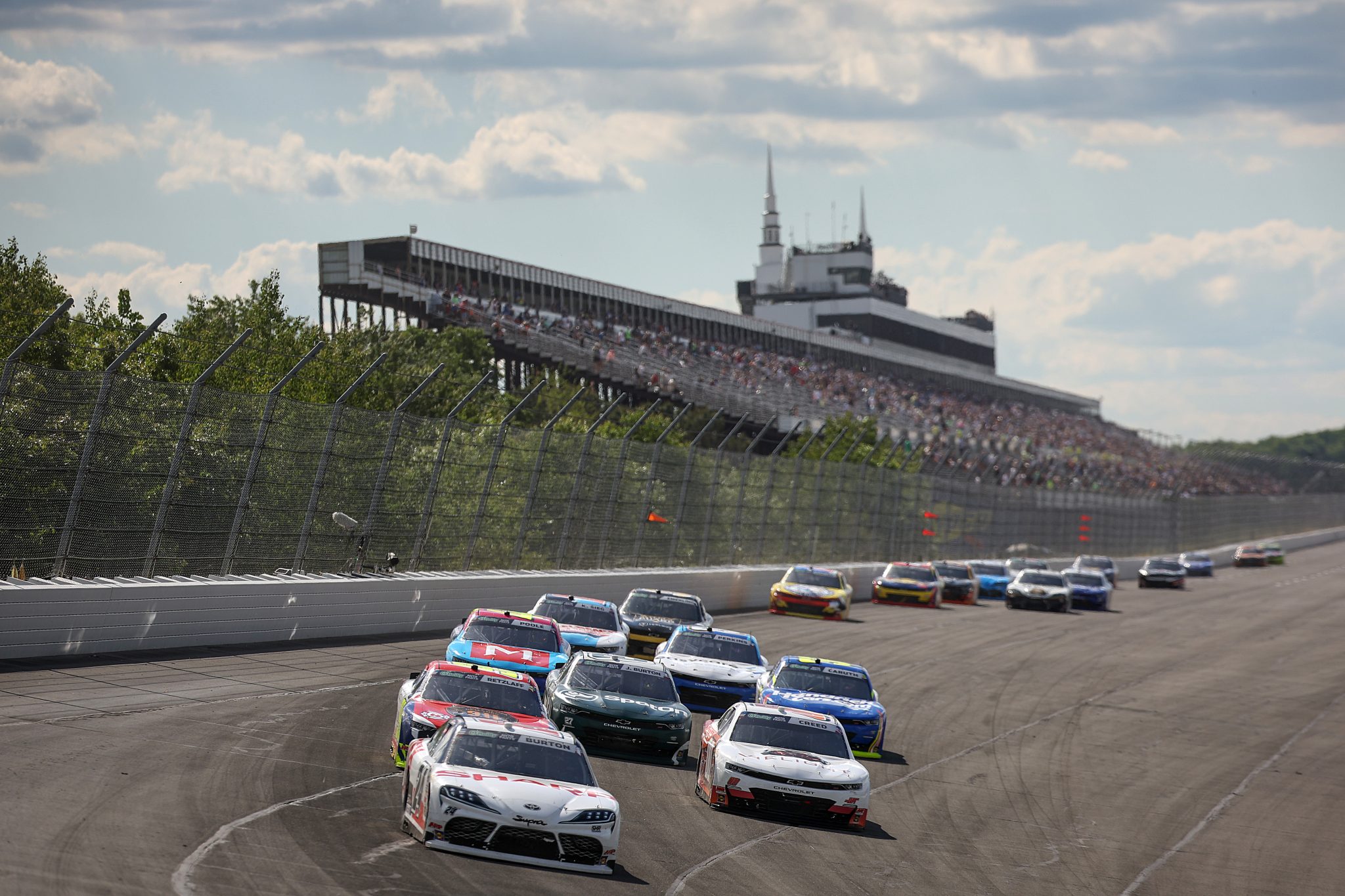LONG POND, PENNSYLVANIA - JUNE 13: Harrison Burton, driver of the #24 DEX/SHARP Toyota, and Sheldon Creed, driver of the #00 VieLight Chevrolet, race during the NASCAR O'Reilly Auto Parts Series MillerTech Battery 250 presented by KOA at Pocono Raceway on June 13, 2026 in Long Pond, Pennsylvania. (Photo by James Gilbert/Getty Images) | Getty Images