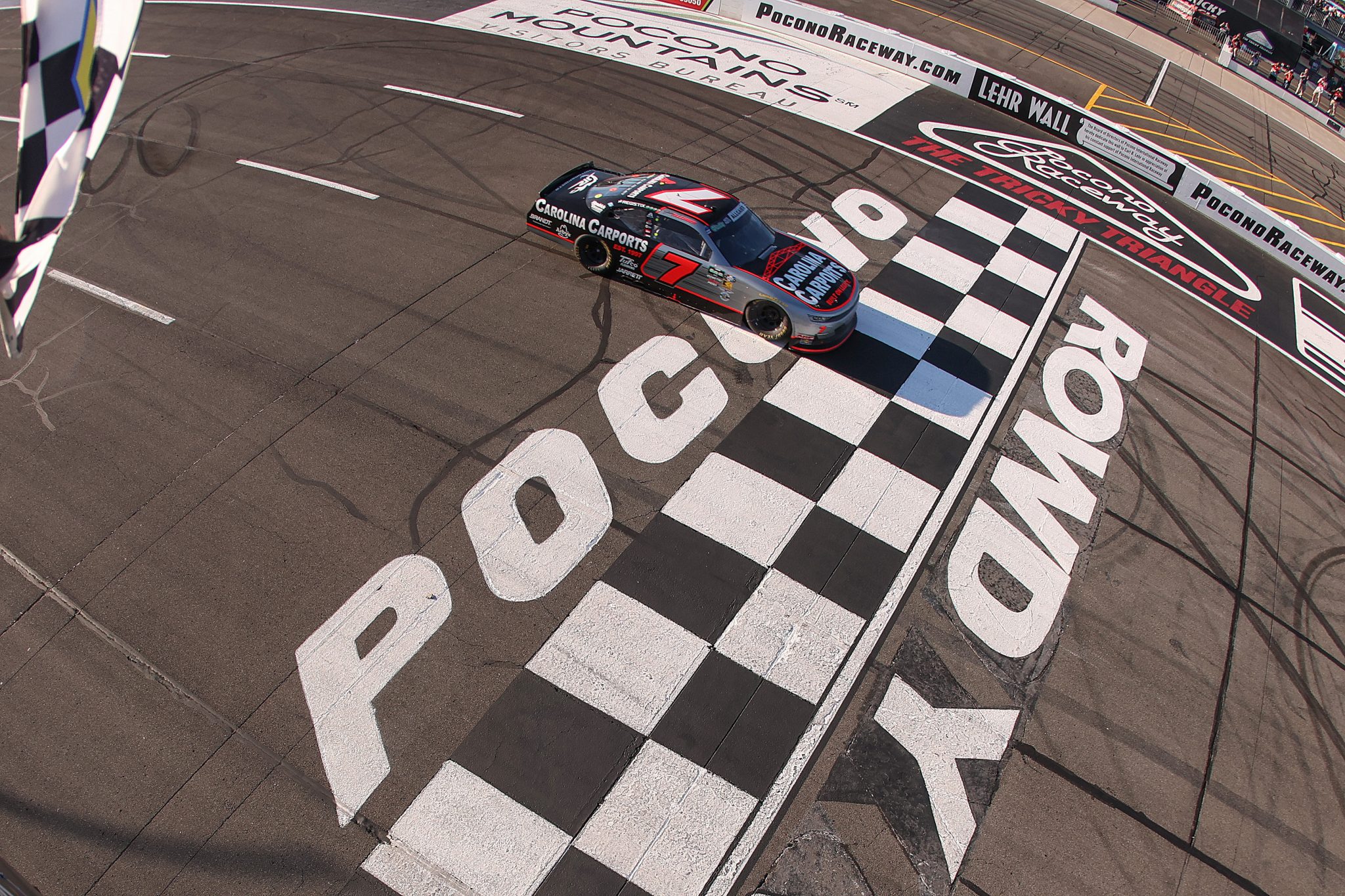LONG POND, PENNSYLVANIA - JUNE 13: Justin Allgaier, driver of the #7 Carolina Carports Chevrolet, takes the checkered flag to win the NASCAR O'Reilly Auto Parts Series MillerTech Battery 250 presented by KOA at Pocono Raceway on June 13, 2026 in Long Pond, Pennsylvania. (Photo by David Jensen/Getty Images) | Getty Images