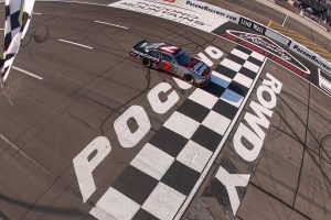 LONG POND, PENNSYLVANIA - JUNE 13: Justin Allgaier, driver of the #7 Carolina Carports Chevrolet, takes the checkered flag to win the NASCAR O'Reilly Auto Parts Series MillerTech Battery 250 presented by KOA at Pocono Raceway on June 13, 2026 in Long Pond, Pennsylvania. (Photo by David Jensen/Getty Images) | Getty Images