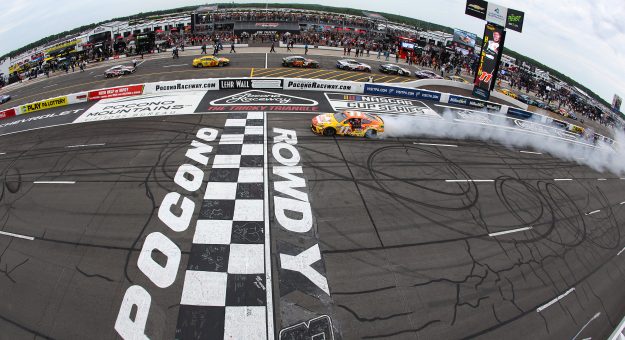 LONG POND, PENNSYLVANIA - JUNE 14: Denny Hamlin, driver of the #11 King's Hawaiian Shake 'Em Bites Toyota, celebrates with a burnout after winning the NASCAR Cup Series Great American Getaway 400 presented by VISITPA at Pocono Raceway on June 14, 2026 in Long Pond, Pennsylvania. (Photo by James Gilbert/Getty Images) | Getty Images