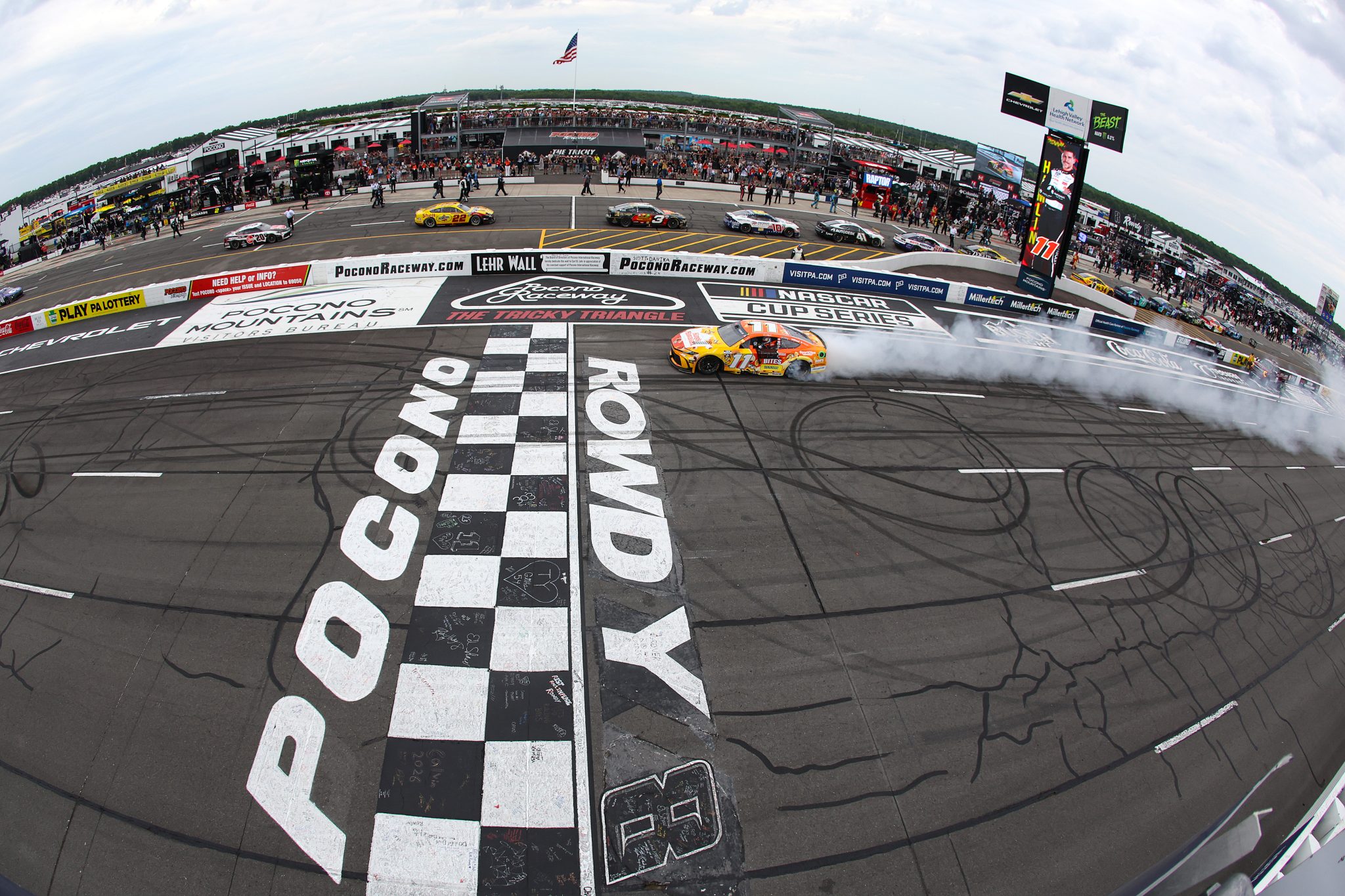 LONG POND, PENNSYLVANIA - JUNE 14: Denny Hamlin, driver of the #11 King's Hawaiian Shake 'Em Bites Toyota, celebrates with a burnout after winning the NASCAR Cup Series Great American Getaway 400 presented by VISITPA at Pocono Raceway on June 14, 2026 in Long Pond, Pennsylvania. (Photo by James Gilbert/Getty Images) | Getty Images