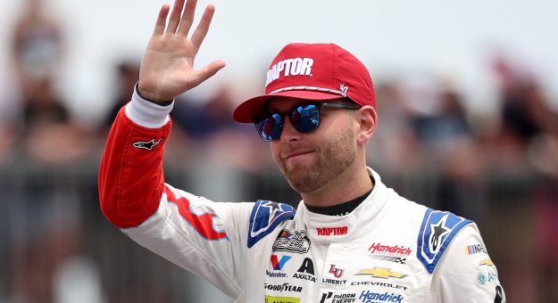 LONG POND, PENNSYLVANIA - JUNE 14: William Byron, driver of the #24 Raptor Chevrolet, waves to fans as he walks onstage during driver intros prior to the NASCAR Cup Series Great American Getaway 400 presented by VISITPA at Pocono Raceway on June 14, 2026 in Long Pond, Pennsylvania. (Photo by James Gilbert/Getty Images) | Getty Images