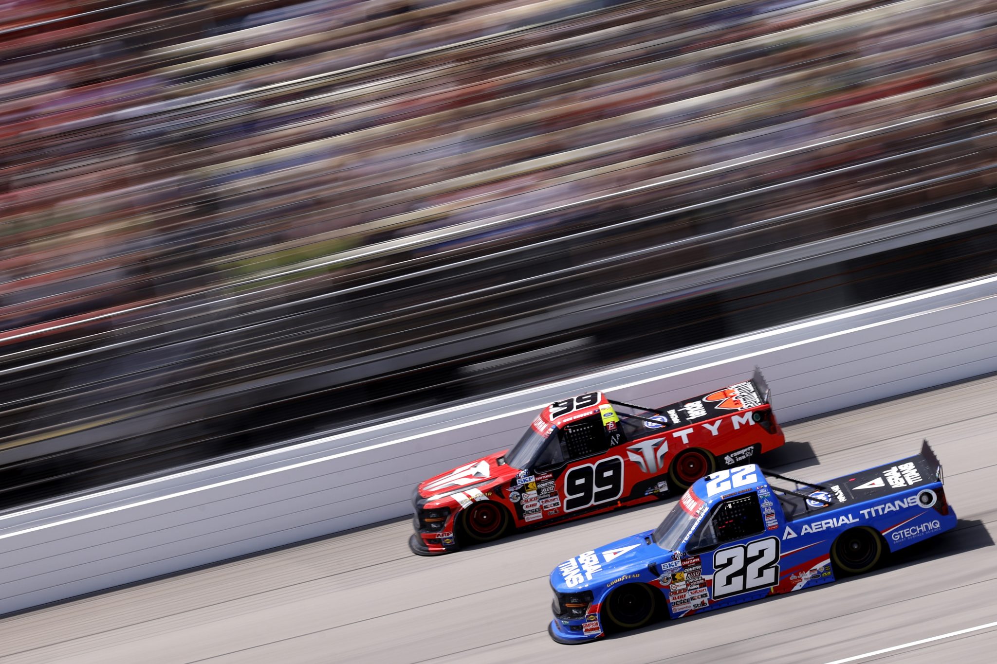 BROOKLYN, MICHIGAN - JUNE 06: Josh Reaume, driver of the #22 Aerial Titans Ford, and Ben Rhodes, driver of the #99 TYM Ford, race during the NASCAR Craftsman Truck Series DQS Solutions & Staffing 250 presented by Precision Vehicle Logistics at Michigan International Speedway on June 06, 2026 in Brooklyn, Michigan. (Photo by Sean Gardner/Getty Images) | Getty Images