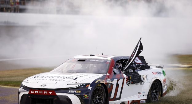 BROOKLYN, MICHIGAN - JUNE 07: Denny Hamlin, driver of the #11 National Debt Relief Toyota, celebrates with a burnout after winning the NASCAR Cup Series FireKeepers Casino 400 at Michigan International Speedway on June 07, 2026 in Brooklyn, Michigan. (Photo by Sean Gardner/Getty Images) | Getty Images