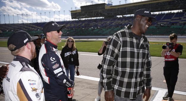 KANSAS CITY, KANSAS - APRIL 18: Michael Jordan, NBA Hall of Famer and Denny Hamlin, driver of the #11 National Debt Relief Toyota, (L) co-owners of 23XI Racing share a laugh with Tyler Reddick, driver of the #45 Supply House Toyota, (R) after winning the pole award during practice for the NASCAR Cup Series AdventHealth 400 at Kansas Speedway on April 18, 2026 in Kansas City, Kansas. (Photo by Sean Gardner/Getty Images) | Getty Images