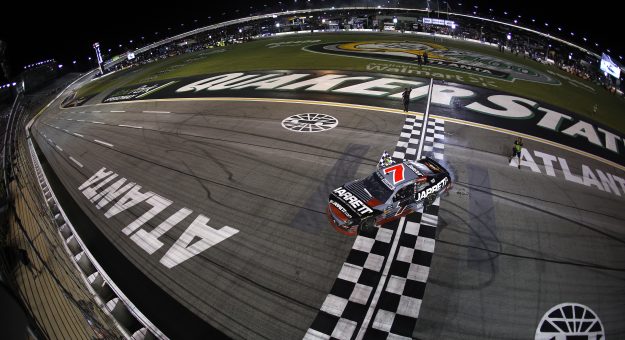 HAMPTON, GEORGIA - JULY 11: Justin Allgaier, driver of the #7 Jarrett Logistics Chevrolet, drives with the checkered flag after winning the NASCAR O'Reilly Auto Parts Series Focused Health 250 at EchoPark Speedway on July 11, 2026 in Hampton, Georgia. (Photo by Sean Gardner/Getty Images) | Getty Images