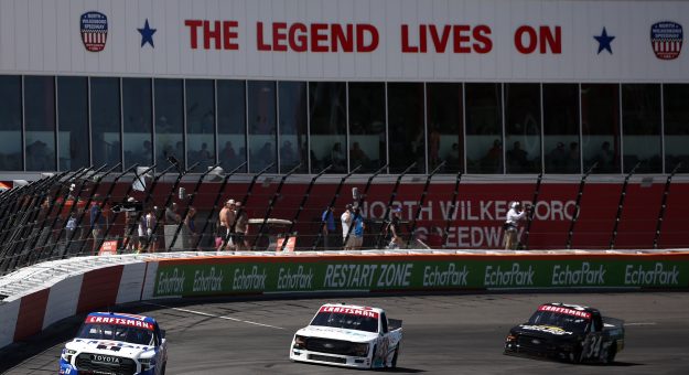 NORTH WILKESBORO, NORTH CAROLINA - MAY 17: Corey Heim, driver of the #11 Mobil 1 Toyota, Chandler Smth, driver of the #38 QuickTie Ford, and Layne Riggs, driver of the #34 UNC Charlotte Ford, race during the NASCAR Craftsman Truck Series Window World 250 at North Wilkesboro Speedway on May 17, 2025 in North Wilkesboro, North Carolina. (Photo by James Gilbert/Getty Images) | Getty Images
