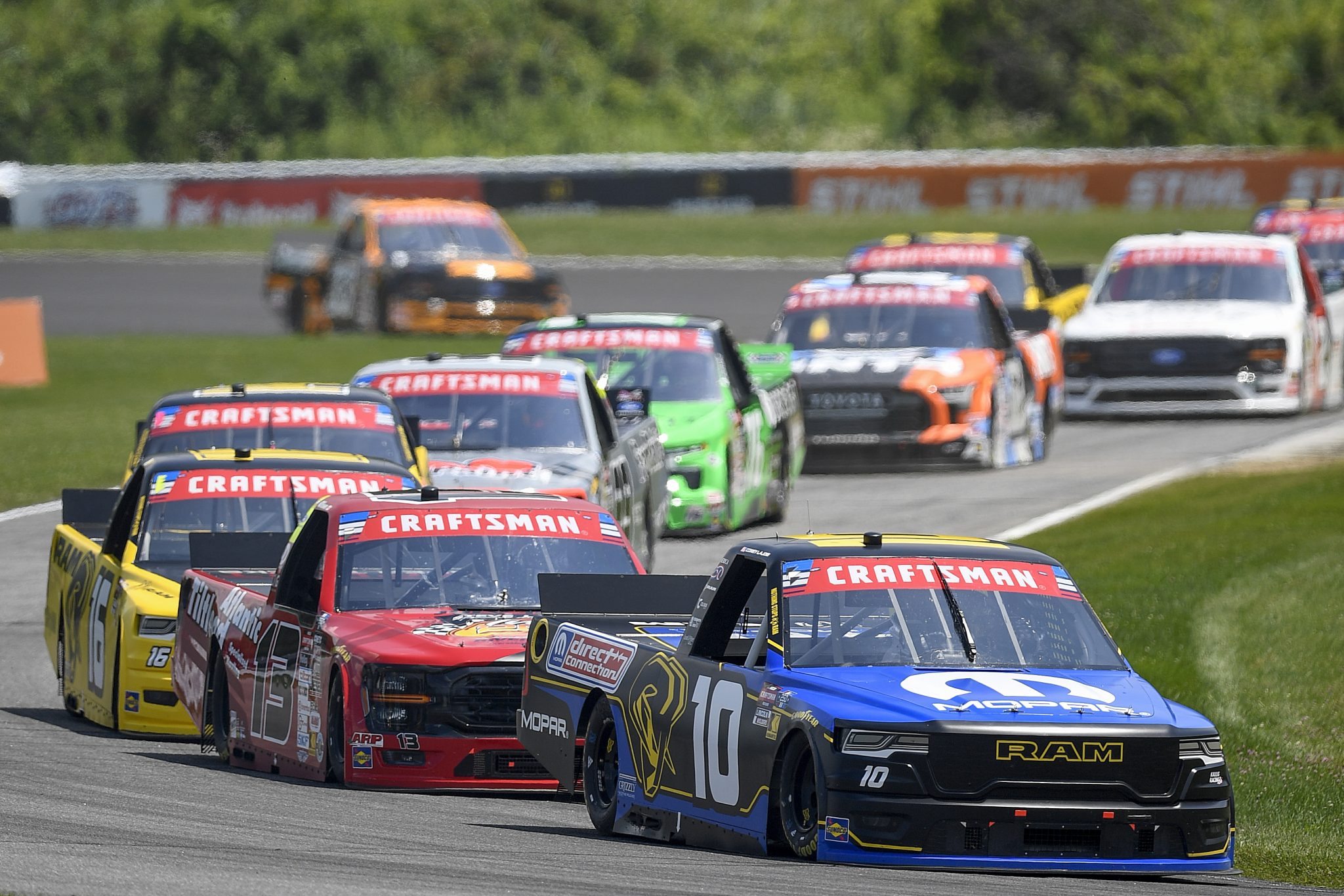 LAKEVILLE, CONNECTICUT - JULY 11: Corey LaJoie, driver of the #10 Mopar RAM, and Cole Butcher, driver of the #13 Atlantic Tilt Load Ford, race during the NASCAR Craftsman Truck Series LiUNA 150 at Lime Rock Park on July 11, 2026 in Lakeville, Connecticut. (Photo by Jaiden Tripi/Getty Images) | Getty Images