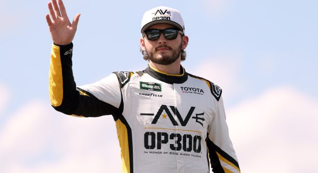 LONG POND, PENNSYLVANIA - JUNE 13: Taylor Gray, driver of the #54 Operation 300 Toyota, waves to fans as he walks onstage during driver intros prior to the NASCAR O'Reilly Auto Parts Series MillerTech Battery 250 presented by KOA at Pocono Raceway on June 13, 2026 in Long Pond, Pennsylvania. (Photo by David Jensen/Getty Images) | Getty Images