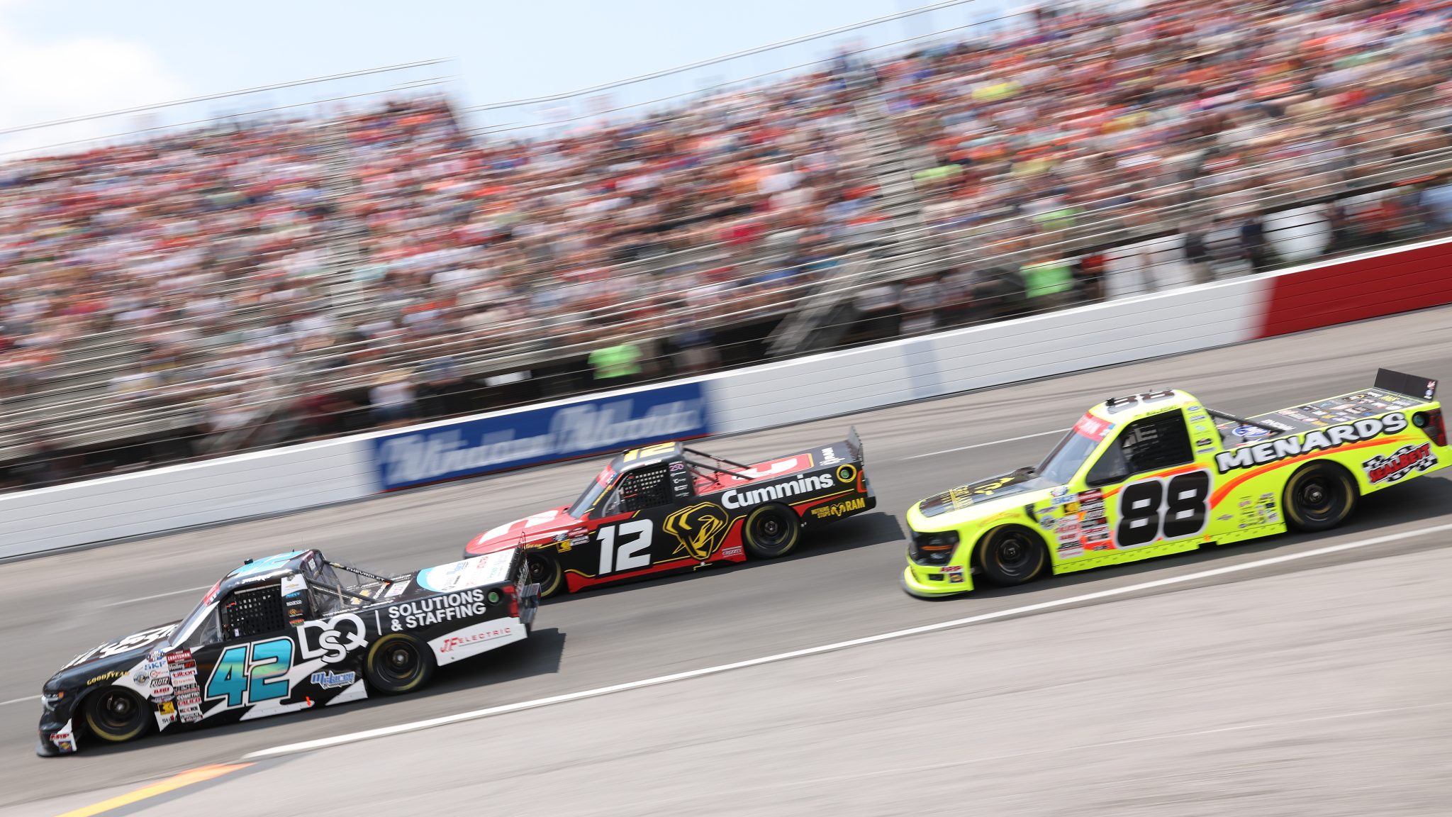 NORTH WILKESBORO, NORTH CAROLINA - JULY 18: Tyler Reif, driver of the #42 AutoVentive/Precision Vehicle Logistics Chevrolet, Brenden Queen, driver of the #12 Cummins RAM and Ty Majeski, driver of the #88 Great Lakes Flooring/Menards Ford race during the NASCAR Craftsman Truck Series Faith Fest 250 at North Wilkesboro Speedway on July 18, 2026 in North Wilkesboro, North Carolina. (Photo by David Jensen/Getty Images) | Getty Images