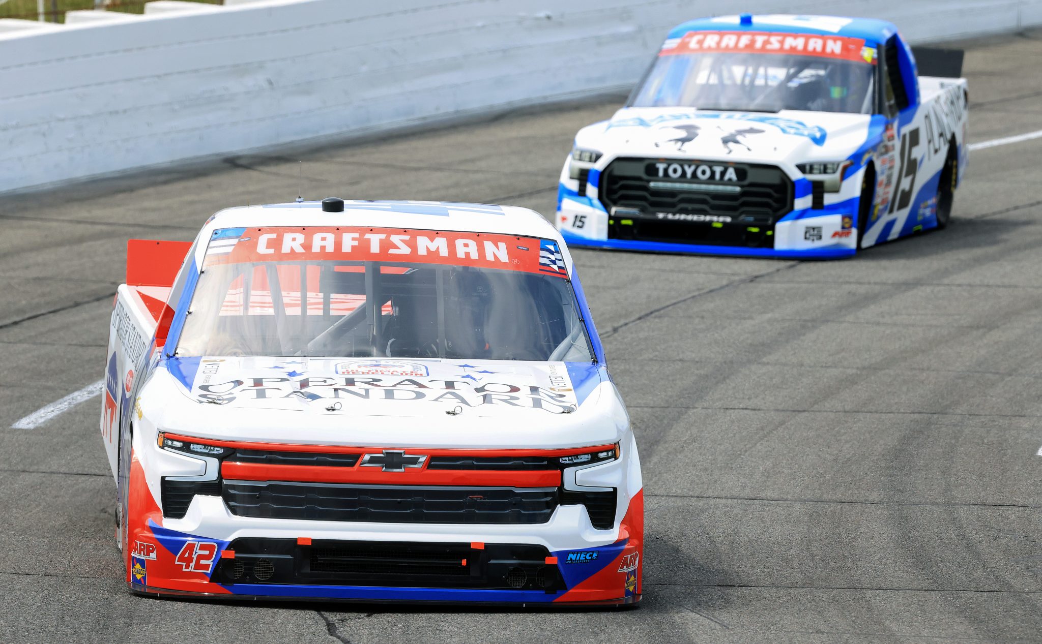 INDIANAPOLIS, INDIANA - JULY 24: Parker Eatmon, driver of the #42 Operator Standard Chevrolet, and Tanner Gray, driver of the #15 Place of Hope Toyota, drive during practice for the NASCAR Craftsman Truck Series TSport 200 at Lucas Oil Indianapolis Raceway Park on July 24, 2026 in Indianapolis, Indiana. (Photo by Justin Casterline/Getty Images) | Getty Images