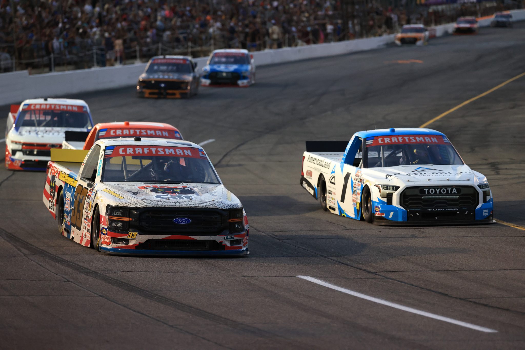 INDIANAPOLIS, INDIANA - JULY 24: Frankie Muniz, driver of the #33 Black Cat Fireworks Ford, and Gavan Boschele, driver of the #1 American Land Partners Toyota, race during the NASCAR Craftsman Truck Series TSport 200 at Lucas Oil Indianapolis Raceway Park on July 24, 2026 in Indianapolis, Indiana. (Photo by Justin Casterline/Getty Images) | Getty Images