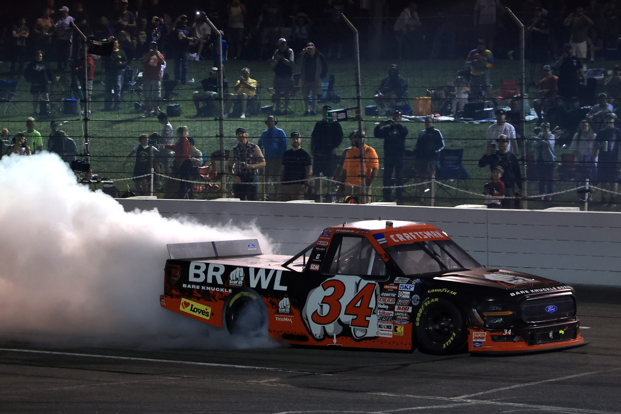 INDIANAPOLIS, INDIANA - JULY 24: Layne Riggs, driver of the #34 BKB Bare Knuckle Boxing Ford, celebrates with a burnout after winning the NASCAR Craftsman Truck Series TSport 200 at Lucas Oil Indianapolis Raceway Park on July 24, 2026 in Indianapolis, Indiana. (Photo by Justin Casterline/Getty Images) | Getty Images