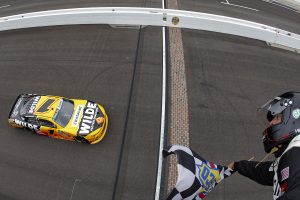 INDIANAPOLIS, INDIANA - JULY 25: Carson Kvapil, driver of the #1 Wilde Protein Crackers Chevrolet, takes the checkered flag to win the NASCAR O'Reilly Auto Parts Series Pennzoil 250 Presented by Take 5 Oil Change at Indianapolis Motor Speedway on July 25, 2026 in Indianapolis, Indiana. (Photo by Sean Gardner/Getty Images) | Getty Images