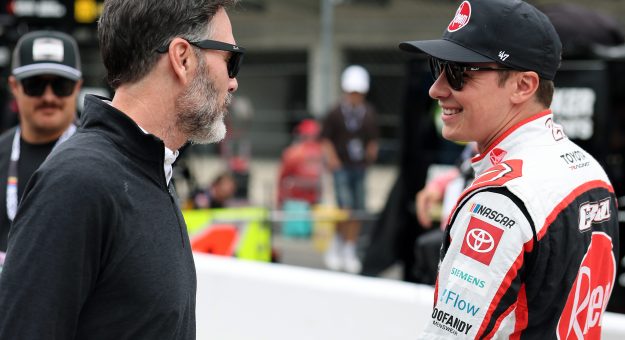 INDIANAPOLIS, INDIANA - JULY 25: Christopher Bell, driver of the #20 Rheem Toyota, (R) speaks to NASCAR Hall of Famer and co-owner of Legacy Motor Club, Jimmie Johnson during qualifying for the NASCAR Cup Series Brickyard 400 at Indianapolis Motor Speedway on July 25, 2026 in Indianapolis, Indiana. (Photo by Logan Riely/Getty Images) | Getty Images
