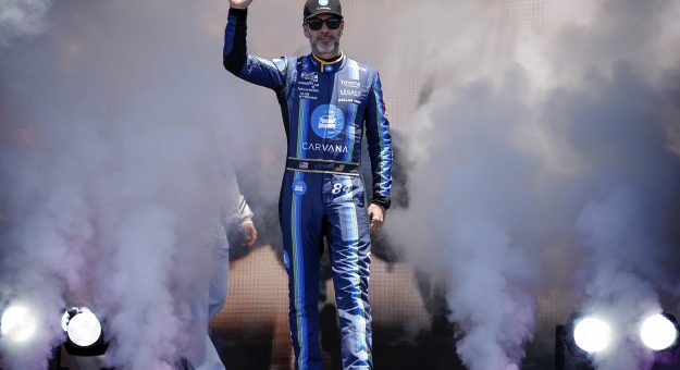 SAN DIEGO, CALIFORNIA - JUNE 21: Jimmie Johnson, driver of the #84 Carvana Toyota, waves to fans as he walks onstage during driver intros prior to the NASCAR Cup Series Anduril 250 at Naval Base Coronado on June 21, 2026 in San Diego, California. (Photo by Sean Gardner/Getty Images) | Getty Images