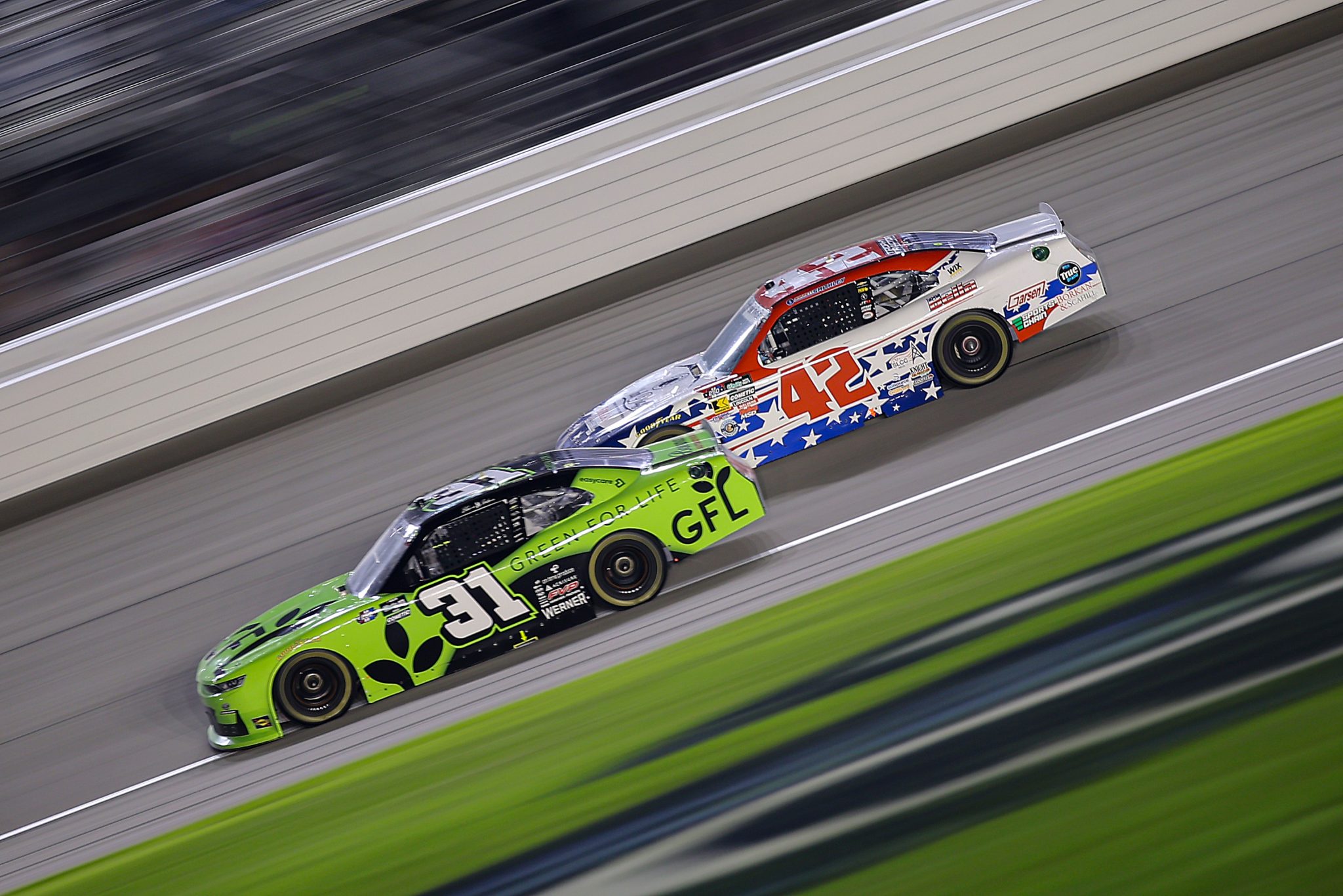 JOLIET, ILLINOIS - JULY 04: Blaine Perkins, driver of the #31 GFL Green for Life Chevrolet, and Garrett Smithley, driver of the #42 Borland & Scahill. Ltd. Chevrolet,  race during the NASCAR O'Reilly Auto Parts Series Cuervo 300 at Chicagoland Speedway on July 04, 2026 in Joliet, Illinois. (Photo by Jonathan Bachman/Getty Images) | Getty Images