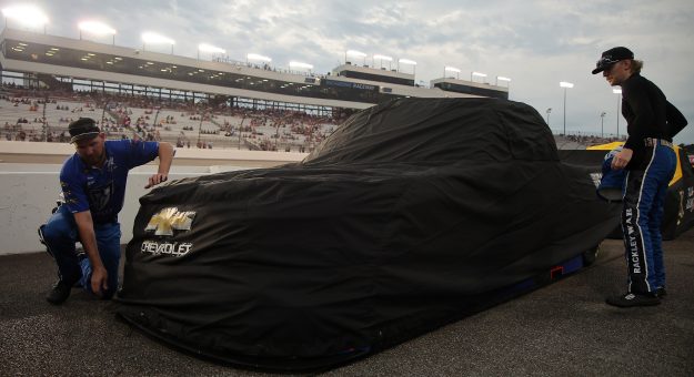 RICHMOND, VIRGINIA - AUGUST 14: Crew members cover the #26 Rackley Roofing Chevrolet driven by Dawson Sutton due to a weather delay of the NASCAR Craftsman Truck Series Black's Tire 250 presented by BTS Rewards at Richmond Raceway on August 14, 2026 in Richmond, Virginia. (Photo by Jonathan Bachman/Getty Images) | Getty Images