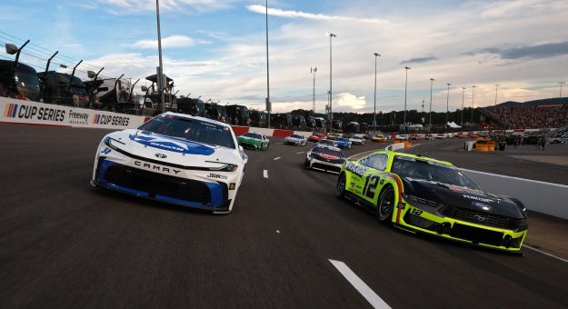 NORTH WILKESBORO, NORTH CAROLINA - JULY 19: Ty Gibbs, driver of the #54 SiriusXM Toyota, and Ryan Blaney, driver of the #12 Menards/Duracell Ford, lead the field during a caution lap during the NASCAR Cup Series Window World 450 at North Wilkesboro Speedway on July 19, 2026 in North Wilkesboro, North Carolina. (Photo by Meg Oliphant/Getty Images) | Getty Images