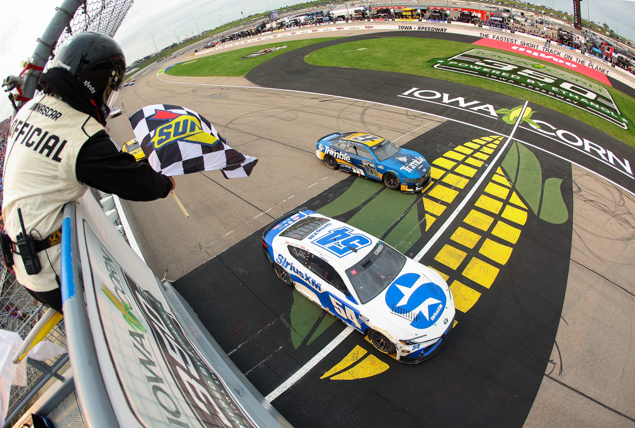 NEWTON, IOWA - AUGUST 09: Ty Gibbs, driver of the #54 SiriusXM Toyota, takes the checkered flag to win the NASCAR Cup Series Iowa Corn 350 Powered by Ethanol at Iowa Speedway on August 09, 2026 in Newton, Iowa. (Photo by Chris Graythen/Getty Images) | Getty Images