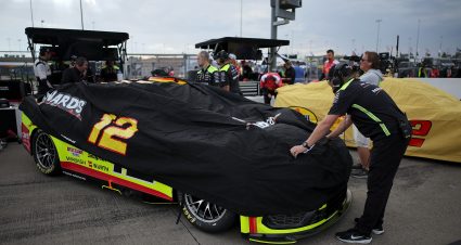 KANSAS CITY, KANSAS - SEPTEMBER 26: Crew members cover the #12 Menards/Cardell Cabinetry Ford driven by Ryan Blaney during a weather delay of practice for the NASCAR Cup Series Hollywood Casino 400 at Kansas Speedway on September 26, 2026 in Kansas City, Kansas. (Photo by Jonathan Bachman/Getty Images) | Getty Images