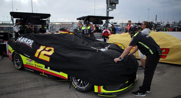KANSAS CITY, KANSAS - SEPTEMBER 26: Crew members cover the #12 Menards/Cardell Cabinetry Ford driven by Ryan Blaney during a weather delay of practice for the NASCAR Cup Series Hollywood Casino 400 at Kansas Speedway on September 26, 2026 in Kansas City, Kansas. (Photo by Jonathan Bachman/Getty Images) | Getty Images